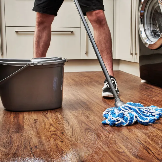 detail-of-a-man-cleaning-a-wooden-kitchen-floor-with-a-mop-news-photo